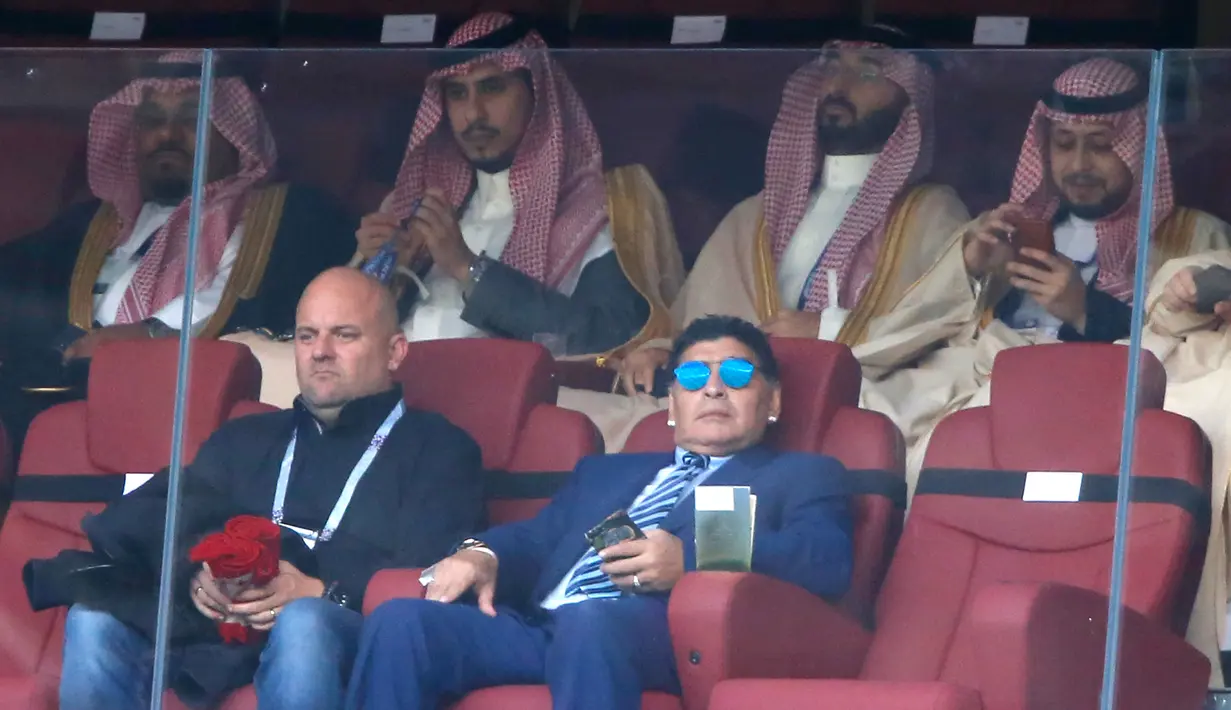 Gaya mantan bintang sepak bola, Diego Maradona (kanan bawah) saat menyaksikan laga antara Rusia dan Arab Saudi dalam Grup A Piala Dunia 2018 di Stadion Luzhniki, Moskow, Rusia, Kamis (14/6). (AP Photo/Hassan Ammar)