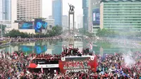 Sejumlah suporter melakukan perayaan bersama pemain Timnas Indonesia U-22 saat mengikuti parade perayaan kesuksesan Timnas Indonesia U-22 di SEA Games 2023 Kamboja di Bundaran Hotel Indonesia, Jakarta, Jumat (19/05/2023). (Bola.com/M Iqbal Ichsan)