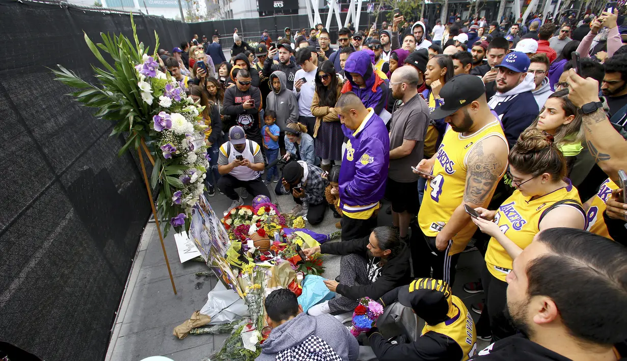 Fans Kobe Bryant berduka saat berkumpul di depan Staples Center, rumah Los Angeles Lakers (26/1/2020). Legenda NBA dan Los Angeles Lakers Kobe Bryant meninggal dunia akibat kecelakaan helikopter di Calabasas, California, Minggu 26 Januari waktu setempat. (AP Photo/Matt Hartman)