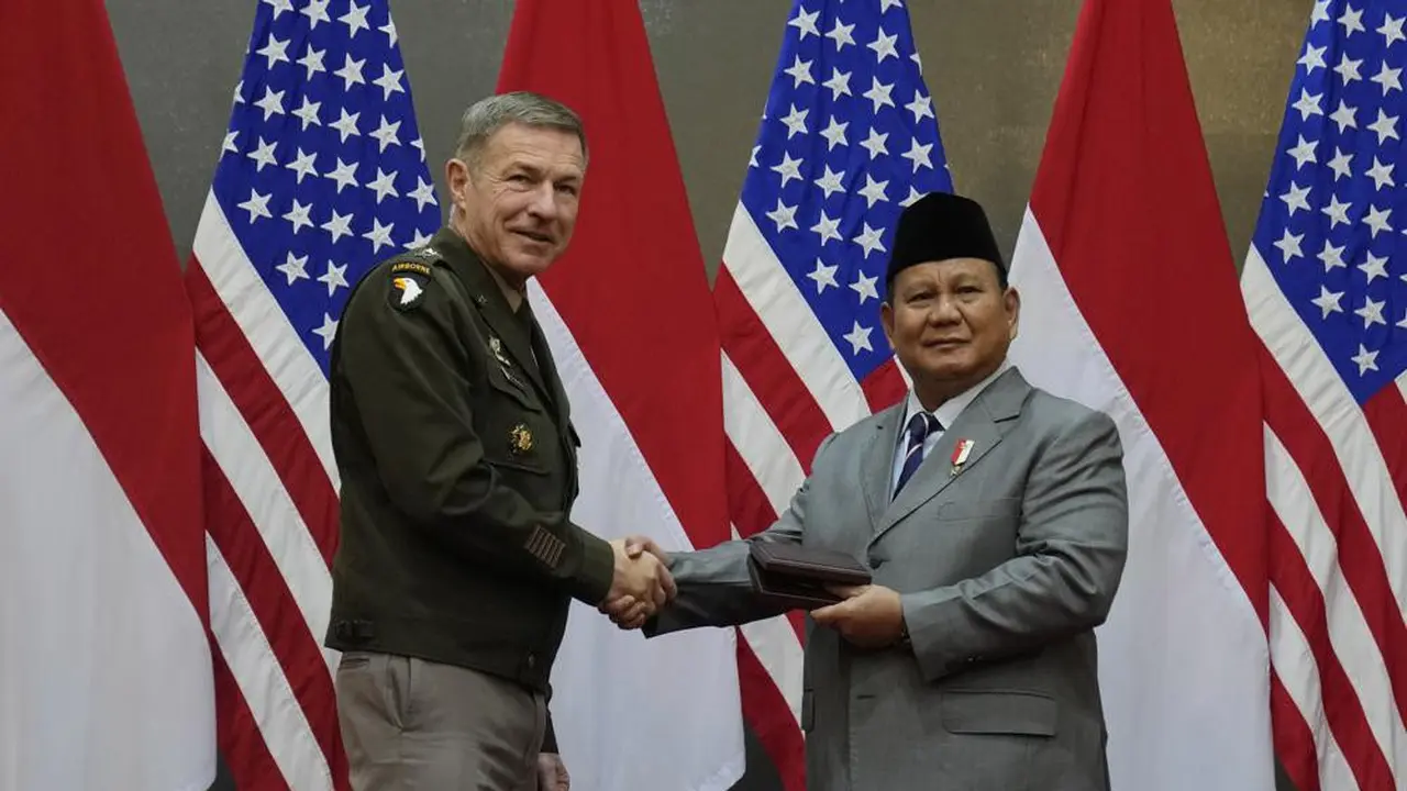 Kepala Staf AD AS Jenderal James McConville (kiri) berjabat tangan dengan Menteri Pertahanan Indonesia Prabowo Subianto saat mereka bertukar cinderamata dalam pertemuan mereka di Jakarta, Indonesia, Jumat, (12/5/2023). (AP Photo/Dita Alangkara)