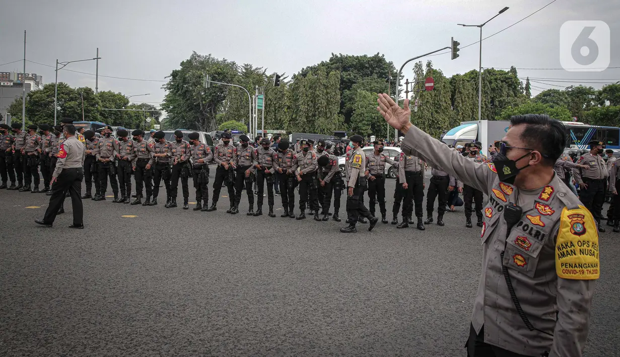 Petugas berjaga saat aksi unjuk rasa mahasiswa di kawasan Harmoni, Jakarta, Jumat (1/4/2022). Dalam aksinya mereka meminta untuk batalkan wacana perpanjangan masa jabatan presiden serta dibatalkannya wacana penundaan pemilu. (Liputan6.com/Faizal Fanani)