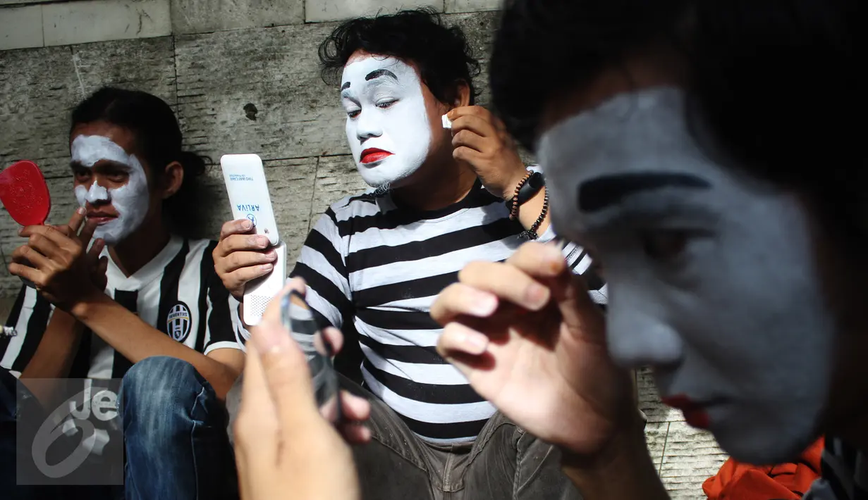Sejumlah pria merias wajahnya jelang memperingati World Mime Day 2017 di CFD, Jakarta, Minggu (19/3). Tanggal 22 Maret adalah hari kelahiran Maestro Mime "Marcel Marceau". (Liputan6.com/Angga Yuniar)