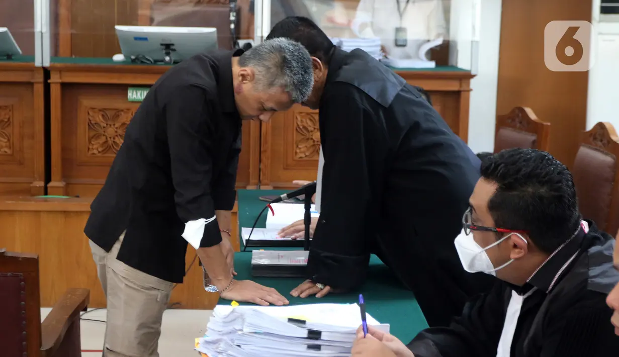 Terdakwa kasus merintangi penyidikan atau "obstruction of justice" pembunuhan berencana terhadap Nofriansyah Yosua Hutabarat atau Brigadir J, Hendra Kurniawan berbincang dengan kuasa hukum sebelum menjalani sidang lanjutan di Pengadilan Negeri Jakarta Selatan, Kamis (1/12/2022). Sidang lanjutan kasus pembunuhan berencana terhadap Brigadir J tersebut kembali digelar dengan agenda pemeriksaan enam saksi yang dihadirkan oleh jaksa penuntut umum.