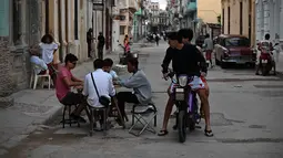 Ini merupakan kejadian kedua dalam sepekan terakhir dan yang ketiga sepanjang Maret 2026. Tampak dalam foto, warga Kuba bermain domino di jalanan tanpa listrik selama pemadaman listrik nasional di Havana, Kuba pada Sabtu 21 Maret 2026. (Yamil LAGE/AFP)