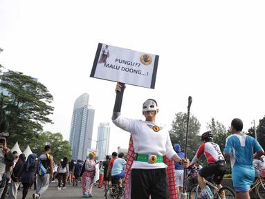 Satgas saber pungli mengenakan kostum super hero mensosialisasikan tolak pungli di Car Free Day, Jakarta, Minggu (12/11). Satuan tugas sapu bersih pungutan liar (saber pungli) terus gencar melakukan sosialisasi anti pungli. (Liputan6.com/Faizal Fanani)