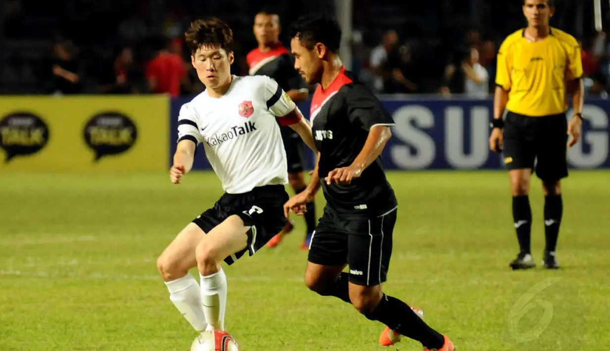 Mantan pemain Manchester United, Park Ji Sung (kiri) mencoba melewati hadangan Ponaryo Astaman (Indonesia All Star) dalam laga persahabatan di Stadion GBK Jakarta, (2/6/2014). (Liputan6.com/Helmi Fithriansyah)