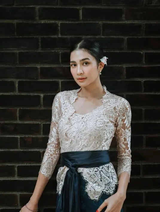 Mikha Tambayong tampil mempesona dalam balutan kebaya Bali berwarna putih gading dengan detail renda yang indah. [@miktambayong].