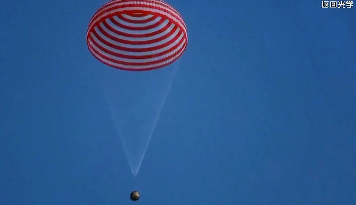 Tangkapan layar menunjukkan kapsul pesawat ruang angkasa Shenzhou-13 yang membawa tiga astronot China bersiap untuk mendarat di Mongolia Dalam, China, 16 April 2022. (CCTV/AFP)
