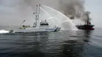 Pasukan penjaga pantai Jepang berusaha memadamkan api di kapal tanker yang meledak di stasiun dekat pantai Prefektur Hyogo, sekitar 450 kilometer barat Tokyo, (29/5/2014). (AFP PHOTO/Japan Coast Guard)