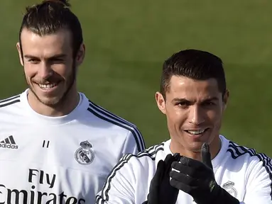 Bintang Real Madrid, Cristiano Ronaldo (kanan) terlihat santai bersama Gareth Bale pada sesi latihan persiapan melawan Getafe di Valdebebas Training Ground, Madrid, Jumat (4/12/2015).  (AFP Photo/Gerard Julien)