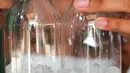 Dika menyelesaikan pembuatan minuman jelly di rumahnya di Kawasan Gandasari, Kecamatan Jatiuwung, Kota Tangerang, Sabtu (21/8/2021). Dika membuat usaha minuman jelly untuk mengisi waktu luangnya di rumah yang dijual melalui pasar online seharga Rp 5 ribu per botolnya. (Liputan6.com/Angga Yuniar)