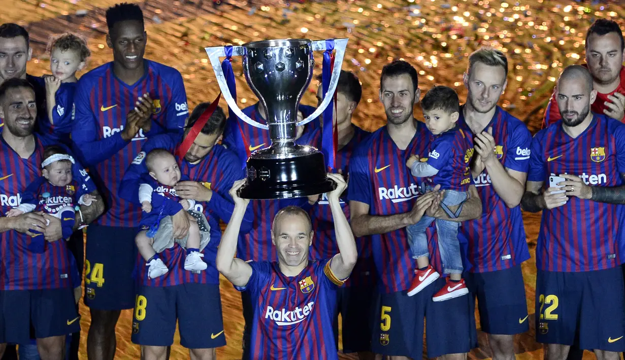 Gelandang Barcelona, Andres Iniesta, mengangkat trofi La Liga Spanyol pada momen perpisahan di Stadion Camp Nou, Barcelona, Minggu (20/5/2018). Dirinya berpisah dengan klub yang 22 tahun telah dibela. (AFP/Lluis Gene)