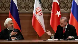Presiden Turki Recep Tayyip Erdogan (kanan) dan Presiden Iran Hassan Rouhani (kiri) saat konferensi pers di Ankara, Turki, Rabu (4/4). Pertemuan ketiganya menghasilkan komitmen untuk mencapai gencatan senjata abadi di Suriah. (AFP PHOTO/ADEM ALTAN)