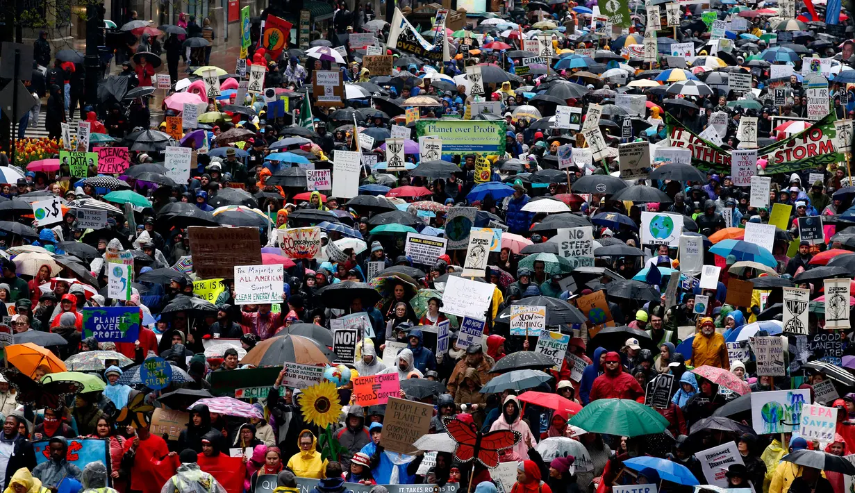 Sejumlah orang melakukan demonstrasi bertepatan 100 hari kerja Trump sebagai presiden di Chicago, AS, Sabtu (29/4). Demonstran memprotes kebijakan Presiden Donald Trump terkait perubahan iklim. (AP Photo / Nam Y. Huh)