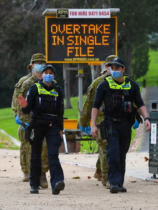 Petugas kepolisian dan tentara berpatroli di jalur lari yang populer di Melbourne, Selasa (4/8/2020). Negara bagian Victoria di Australia, khususnya ibu kota Melbourne mengumumkan status darurat bencana COVID-19 pada Minggu (2/8) waktu setempat. (William WEST / AFP)