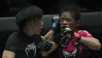 Petarung Cina, Xiong Jing Nan, memukul petarung Singapura, Tiffany Teo, saat laga One Championship di JCC Senayan, Jakarta, Sabtu (20/1/2018). Jing Nan berhasil merebut juara dunia kelas jerami. (Bola.com/Vitalis Yogi Trisna)
