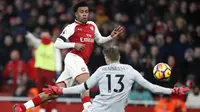 Pemain Arsenal, Alex Iwobi (kiri) mencetak gol setelah mengecoh kiper Crystal Palace, Wayne Hennessey pada lanjutan Premier League di Emirates stadium, London, (20/1/2018). Arsenal menang 4-1. (AP/Frank Augstein)