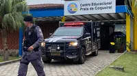 Polisi berdiri di pintu masuk Praia de Coqueiral Educational Center, salah satu dari dua sekolah tempat terjadinya penembakan. (AFP)