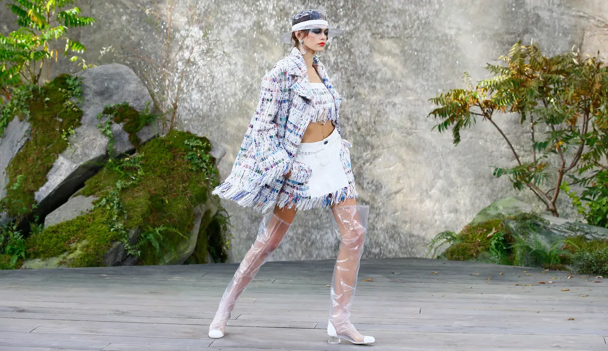 Kaia Gerber mengenakan koleksi Spring/Summer 2018 untuk Chanel selama Paris Fashion Week, Selasa (3/10). Putri mantan supermodel Cindy Crawford ini memakai crop top berumbai dan rok mini dilengkapi jaket berumbai motif senada. (AP Photo/Francois Mori)