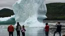 Wisatawan menyaksikan pemandangan gunung es terapung dari pantai King's Point, Newfoundland, Kanada, 3 Juli 2019. Tidak sedikit wisatawan yang datang ke tempat ini untuk mengabadikan pemandangan indah tersebut. (Johannes Eisele/AFP)