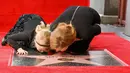 Amy Adams bersama anaknya mencium plakat penghargaan dari Hollywood Walk of Fame di Los Angeles, AS, Kamis (12/1). Adams menerima plakat penghormatan atas perannya di film fiksi ilmiah Paramount Pictures Arrival. (AP Photo/ Rich Fury)