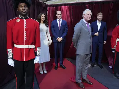 Pria berpakaian pengawal kerajaan berdiri mengawasi patung lilin Raja Charles III, Pangeran William dan Princess of Wales, Kate Middleton serta Pangeran Harry di halaman depan Queen Victoria Building di Sydney, Australia, Rabu (3/5/2023). (AP Photo/Rick Rycroft)