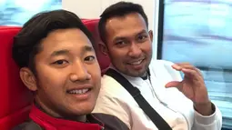 Pevoli pantai Indonesia, Mohammad Ashfiya, bersama pelatihnya, Koko Prasetyo (kanan), naik kereta melintasi Wina, Austria, Kamis (27/7/2017). Tim voli pantai Indonesia akan mengikuti Kejuaraan Dunia di Wina. (Bola.com/Reza Khomaini)