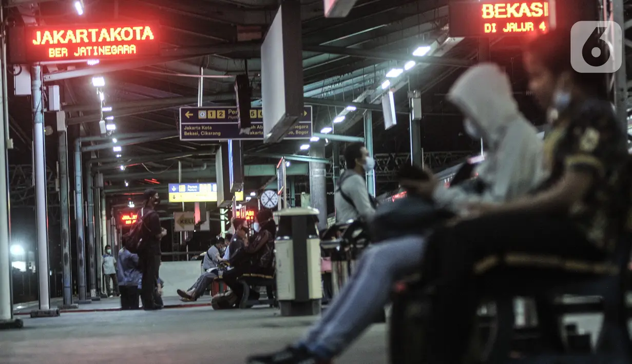 Penumpang menunggu kedatangan KRL di Stasiun Manggarai, Jakarta, Selasa (12/1/2021). Selama PSBB di DKI mulai 11-25 Januari, PT Kereta Commuter Indonesia (KCI) memangkas jadwal operasional KRL menjadi pukul 04.00 WIB hingga 22.00 WIB guna menekan penularan Covid-19. (merdeka.com/Iqbal Nugroho)