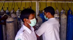 Petugas medis membawa tangki oksigen di sebuah rumah sakit di Lhokseumawe, Aceh, Selasa (7/7/2021). Indonesia memperluas pembatasan untuk memerangi gelombang virus corona COVID-19 yang mematikan. (Azwar Ipank/AFP)