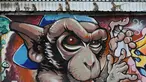 Sejumlah monyet duduk di dinding grafiti saat Festival Monkey Buffet, kawasan kuil Phra Prang Sam Yot, Bangkok, Thailand (27/11). Kota Lopburi menggelar jamuan bagi ratusan monyet. (REUTERS/Chaiwat Subprasom)