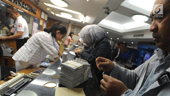 Petugas melayani nasabah di gerai penukaran mata uang di Ayu Masagung, Jakarta, Senin (13/8). Pada perdagangan jadwal pekan, senin (13/08). Nilai tukar rupiah terhadap dolar AS menyentuh posisi tertingginya Rp 14.600. (Merdeka.com/Arie Basuki)