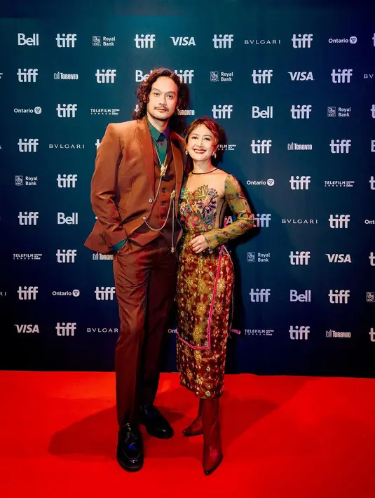 Lalu ada Dwi Sasono sebagai pemeran di film Budi Pekerti mengenakan setelan jas warna coklat dan kemeja hijau. Di sampingnya, ada sang istri Widi Mulia mengenakan dress batik. [@dwisasono]