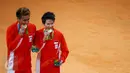 Pasangan ganda campuran Indonesia, Tontowi Ahmad dan Liliyana Natsir mengigit medali emas usai mengalahkan lawannya asal Malaysia Peng Soon Chan dan Liu Ying Goh pada final bulutangkis di Riocentro Pavilion 4 , Brasil. (REUTERS/Mike Blake)