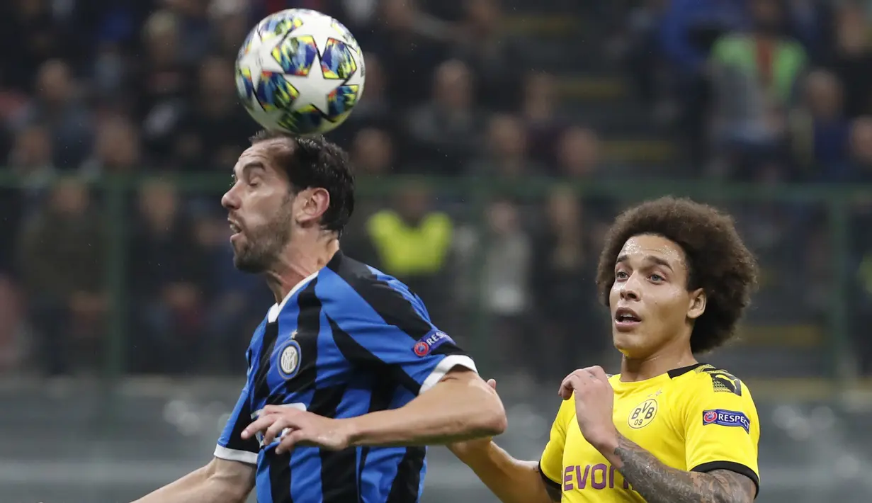 Bek Inter Milan, Diego Godin berebut bola udara dengan gelandang Borrusia Dortmund, Axel Witsel pada pertandingan lanjutan Grup F Liga Champions di stadion San Siro, Italia (23/10/2019). Inter Milan menang 2-0 atas Dortmund. (AP Photo/Antonio Calanni)