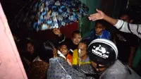Nampak seorang ibu hamil dengan anak balita tengah mendapatkan pertolongan warga akibat banjir di kawasan Garut Kota, kabupaten Garut, Jawa Barat. (Liputan6.com/Jayadi Supriadin)