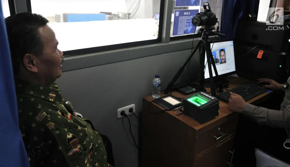 Warga saat menyelesaikan proses pembuatan Smart SIM (Surat Izin Mengemudi) di Jakarta, Minggu (22/9/2019). Proses dalam pembuatan Smart SIM hampir sama dengan SIM konvensional, hanya saja tidak ada pemindaian mata, melainkan sidik jari yang telah tersinkronisasi dengan data kepolisian. (merdeka.com/