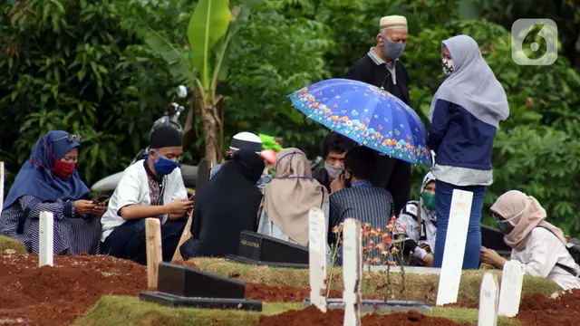 FOTO: Hari Pertama Idul Fitri 1441 H, Keluarga dan Kerabat Lakukan Ziarah Makam Korban COVID-19