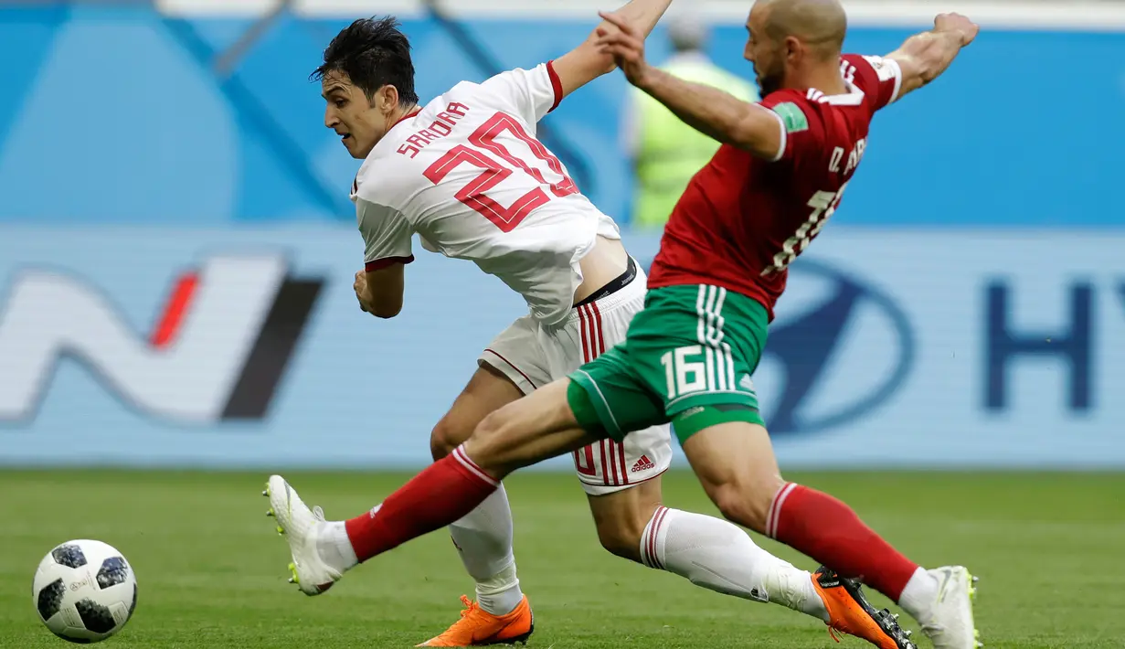 Pemain Iran Sardar Azmoun berusaha melewati pemain Maroko Noureddine Amrabat saat bertanding pada grup B Piala Dunia 2018 di St Petersburg Stadium, Rusia, (15/6). Iran menang tipis 1-0 berkat gol bunuh diri Aziz Bouhaddouz. (AP Photo/Andrew Medichini)