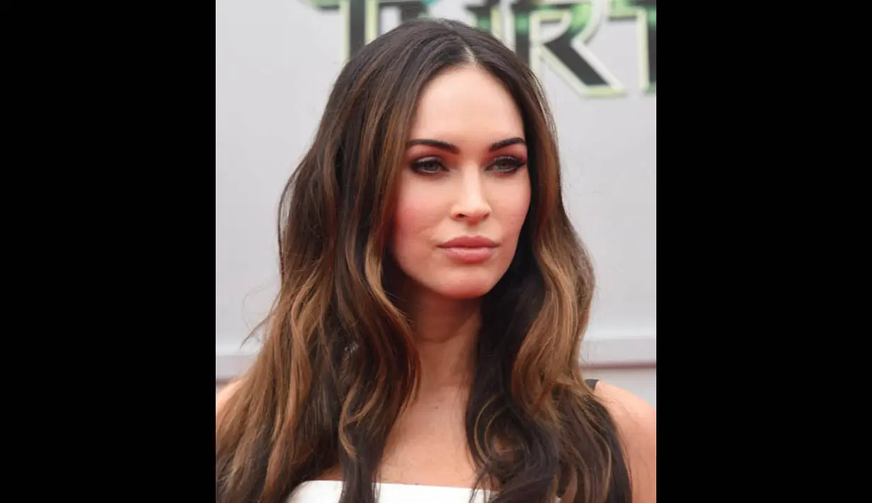 Megan Fox memulaskan eye shadow berwarna gelap dengan eyeliner yang membentuk matanya bak mata kucing serta rambut yang ditata alami, California, (3/8/14). (Kevin Winter/Getty Images for Paramount Pictures/AFP) 