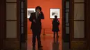 Seorang staf yang mengenakan masker berjalan di sepanjang koridor Museum Seni Nasional China di Beijing, Rabu (1/2/2023). Pengunjung terus berduyun-duyun ke museum, situs bersejarah, dan tempat wisata di ibu kota China saat periode liburan Tahun Baru Imlek berakhir. (AP Photo/Mark Schiefelbein)