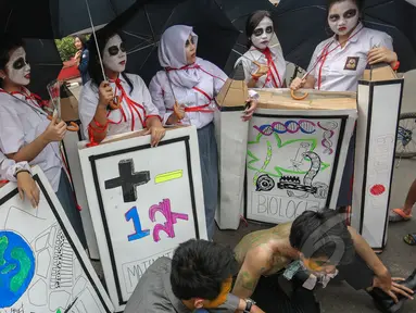 Sejumlah mahasiswa melakukan aksi teatrikal bertema 'Revolusi Pendidikan' dalam rangka memperingati Hari Pendidikan Nasional (Hardiknas) di Bundaran HI, Jakarta, Minggu (3/5/2015). (Liputan6.com/Faizal Fanani) 