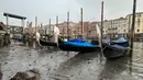 Gondola berlabuh di sepanjang kanal saat air surut di Venesia, Italia, 18 Februari 2023. Keringnya sejumlah kanal sekunder Venesia membuat gondola, taksi air, dan ambulans tidak dapat menavigasi beberapa kanal terkenalnya. (AP Photo/Luigi Costantini)