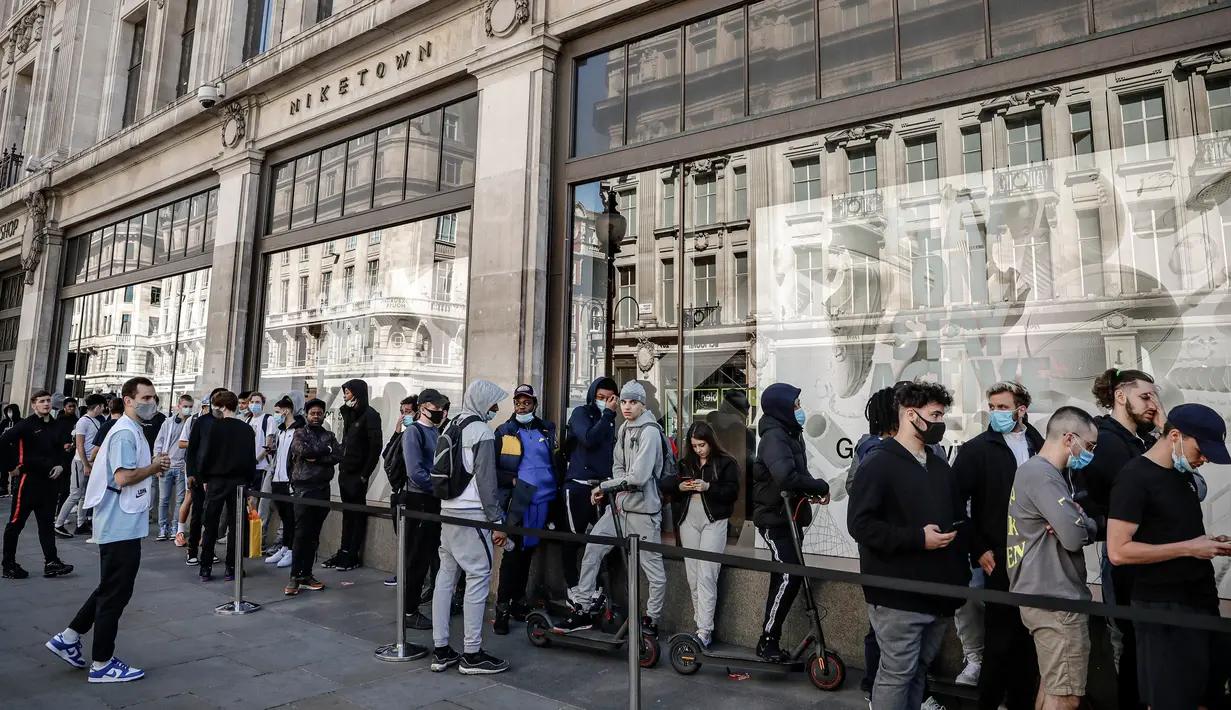 Orang-orang antre di luar toko Niketown di London, Senin (15/6/2020). Antrean panjang terjadi di luar toko-toko yang berada di sejumlah kota di Inggris saat negara itu melakukan pelonggaran lockdown dan mulai membuka pusat perbelanjaan. (AP/Matt Dunham)