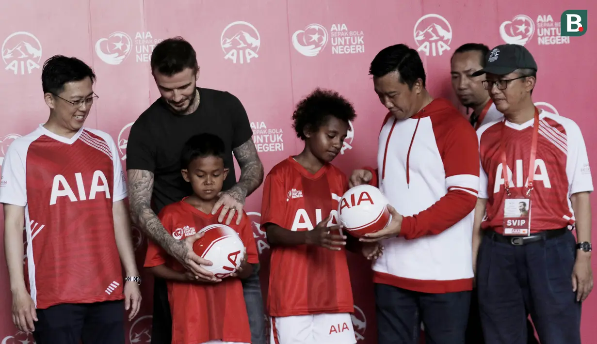 Legenda sepak bola Inggris, David Beckham, dan Menpora RI, Imam Nahrawi, membagikan bola di Stadion Soemantri Brodjonegoro, Jakarta, Minggu (25/3/2018). AIA membagikan 10.000 bola kepada akademi sepak bola di Indonesia. (Bola.com/M Iqbal Ichsan)