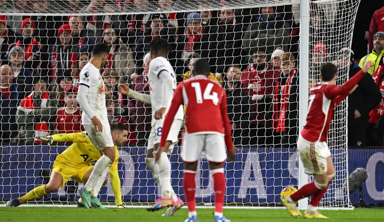 Pemain Nottingham Forest, Neco Williams (kanan), gagal menjebol gawang Tottenham Hotspur yang dijaga oleh Guglielmo Vicario dalam pertandingan pekan ke-17 Liga Inggris 2023/2024 yang berlangsung di The City Ground, Sabtu (16/12/2023) dini hari WIB. (AFP/Oli Scarff)