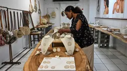 Bengkel butik di Port Moresby menampung sekelompok wanita yang berspesialisasi dalam menenun bahan tanaman dengan rumit ke dalam tas yang dikenal sebagai bilum, simbol kebanggaan Pribumi. (ADEK BERRY/AFP)