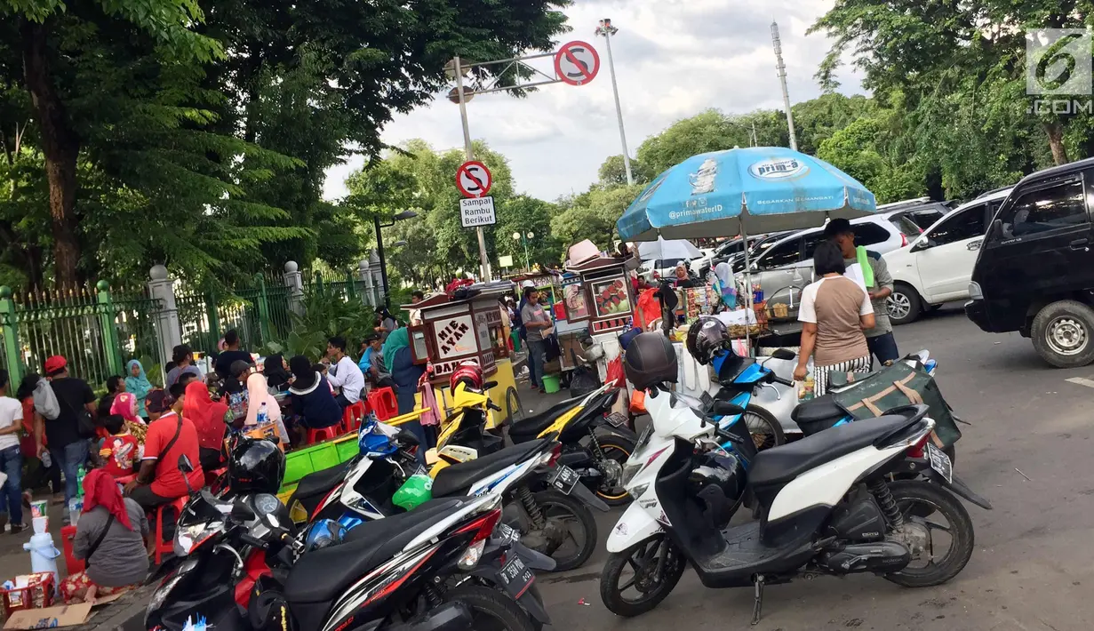 PKL dan parkir liar memenuhi akses jalan di sekitar kawasan Monas, Jakarta, Senin (1/1). Kurangnya pengawasan menyebabkan banyak PKL dan parkir liar memenuhi kawasan tersebut sehingga menimbulkan kesemrawutan. (Liputan6.com/Immanuel Antonius)