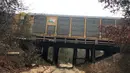 Salah satu gerbong berada di atas jembatan saat terjadi tabrakan antara kereta Amtrak dan kereta barang CSX di South Carolina (4/2). (Tim Dominick/The State)