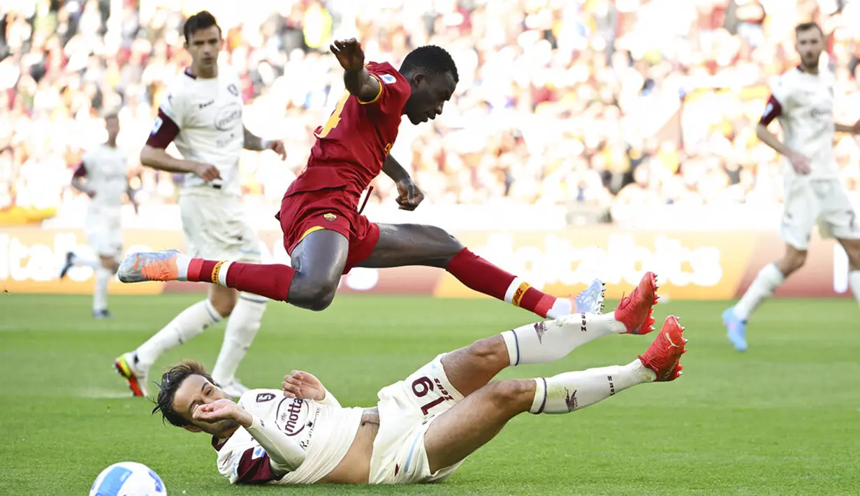 Pemain AS Roma Felix Afena (atas) berebut bola dengan pemain Salernitana Luca Ranieri pada pertandingan sepak bola Serie A di Olympic Stadium, Roma, Italia, 10 April 2022. AS Roma menang dramatis 2-1. (Alfredo Falcone/LaPresse via AP)