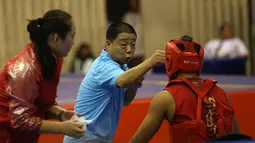 Atlet Wushu Asal China, mendengar instruksi pelatihnya pada Cabang Sanda Kejuaraan Dunia Wushu 2015 di Istora, Senayan, Jakarta,Rabu (18/11/2015). (Bola.com/Nicklas Hanoatubun)